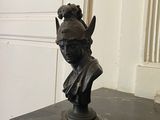 a statue of a woman wearing a helmet on top of a table
