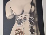 a black and white photo of a man ' s torso with gauges