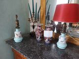 une table sur laquelle se trouvent une lampe, des vases et un miroir
