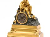 une horloge en or sur laquelle est assis un homme