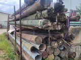 a pile of logs sitting in the grass next to a building