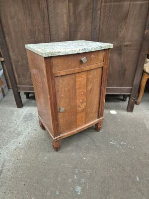 une petite armoire posée à même le sol, avec un plateau en marbre