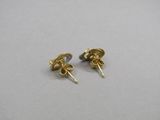une paire de boucles d'oreilles en or sur un fond blanc
