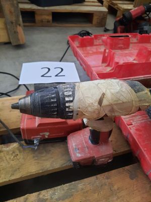 une perceuse posée sur une boîte rouge