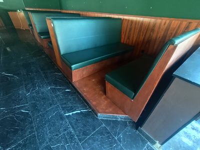 des tables et des bancs dans un restaurant aux murs verts et aux boiseries