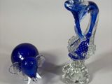 two blue glass vases sitting next to each other on a white surface