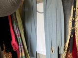 a woman that is standing in front of a rack of clothes