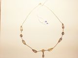gold necklace with a long chain and a pendant with a bird on it