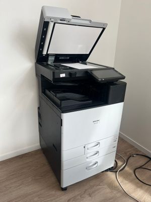 a black and white printer sitting on top of a white cabinet