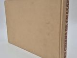 a book with a brown cover sitting on top of a white surface
