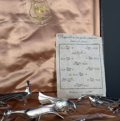 trois figurines en argent dans un coffret posé sur une table