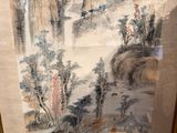 painting of a mountain scene in a gold frame on a wall