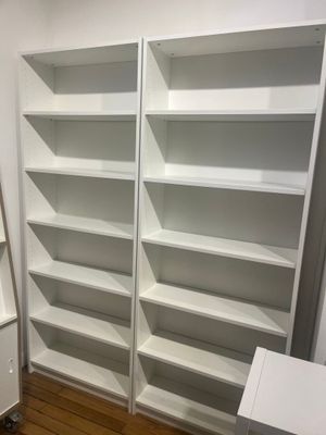 une bibliothèque blanche dans un coin de la pièce