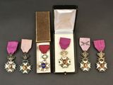 Les trois médailles se trouvent dans un écrin orné d'un ruban rose et d'un ruban violet