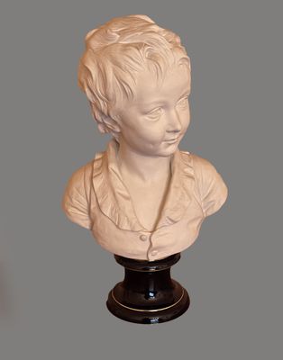 a white bust of a boy with a necklace on it
