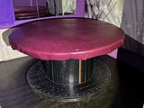 a round table with a red top in a purple room