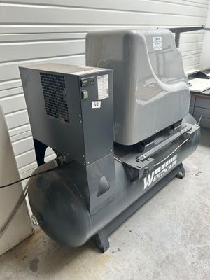 deux compresseurs d'air placés l'un à côté de l'autre dans un garage
