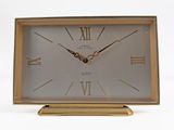 a gold clock with roman numerals on the face