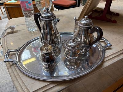 un plateau en argent posé sur une table, sur lequel se trouvent des couverts