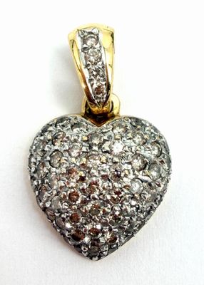 une image représentant un pendentif en forme de cœur en diamant posé sur une surface blanche