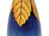 a blue vase with a yellow leaf design on it