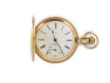 a gold pocket watch with roman numerals on the face