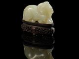 une image représentant une bague en forme d'éléphant en jade sur un fond noir