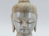 a close up of a statue of a person with a bun on his head