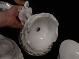 a person that is holding a tea pot and some plates