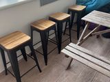 four stools and a table in the corner of a room
