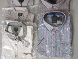three men ' s shirts wrapped in plastic bags on a table