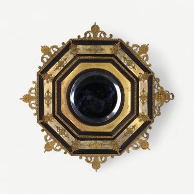a black and gold plate with a black bowl in it