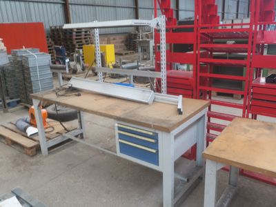 un établi dans un entrepôt où se trouvent de nombreux outils