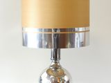 lampe de table argentée avec un abat-jour doré sur fond blanc