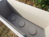 a white box with three buttons in it sitting on the grass