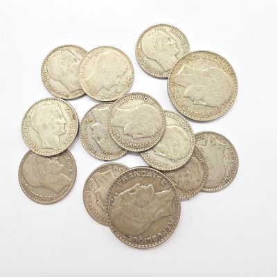 quelques pièces d'argent empilées les unes sur les autres sur une surface blanche
