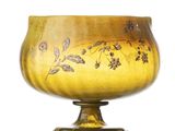 a yellow glass vase with a floral design on it