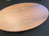 a wooden table with a black top on a black surface