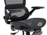 La chaise de bureau est noire et dispose d'un dossier et d'une assise en maille.