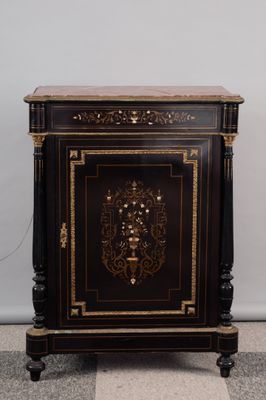 un meuble noir et doré avec un plateau en marbre