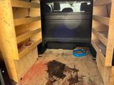 the inside of a van with the back door open and shelves in the back