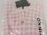 a pink and white sweater in a plastic bag on a white surface
