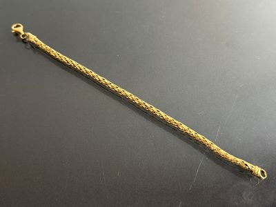a close up of a gold bracelet on a black surface