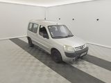 une petite camionnette blanche garée dans une pièce au sol carrelé