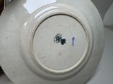 a white plate with a green flower on it