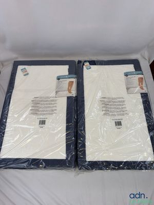deux draps blancs sont emballés dans du plastique sur un lit