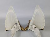 pair of white glass sconces with gold accents on a white background