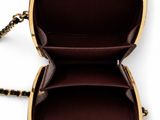 a close up of a black and gold purse with a chain