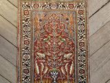 un tapis persan ancien à franges posé sur un parquet