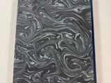 a black and white marbled notebook sitting on top of a white table